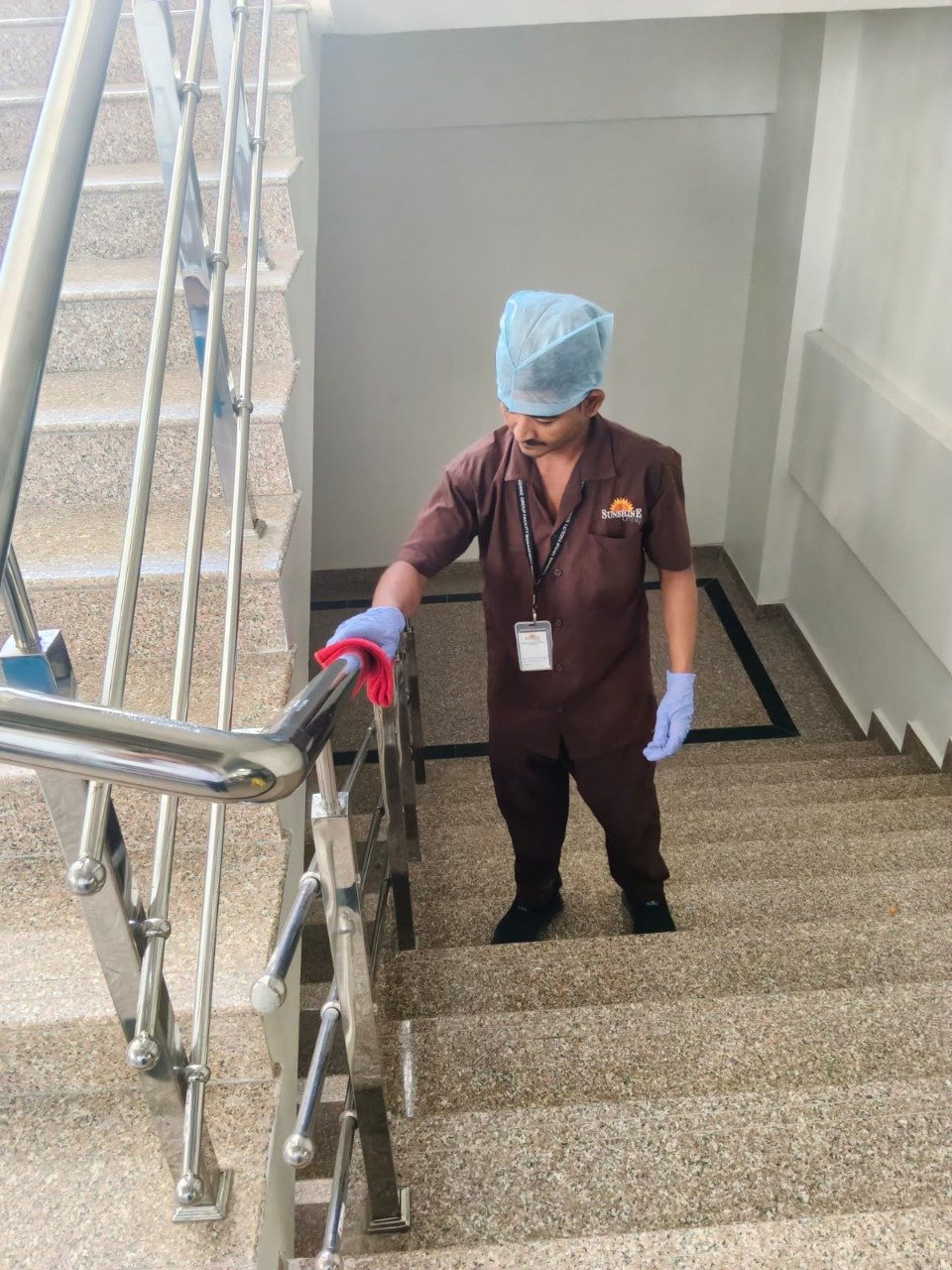 Housekeeping staff sanitizing office railing